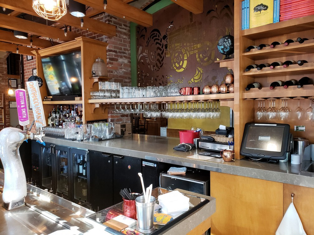 A shelf and wine glass rack was built to span between the cabinets in this downtown restaurant.